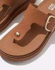 Ergonomic HE7 592 Light Tan FitFlop sandals with brushed-metal buckle, domed stud, natural arch support, and lightweight cork-mix sole for everyday wear.