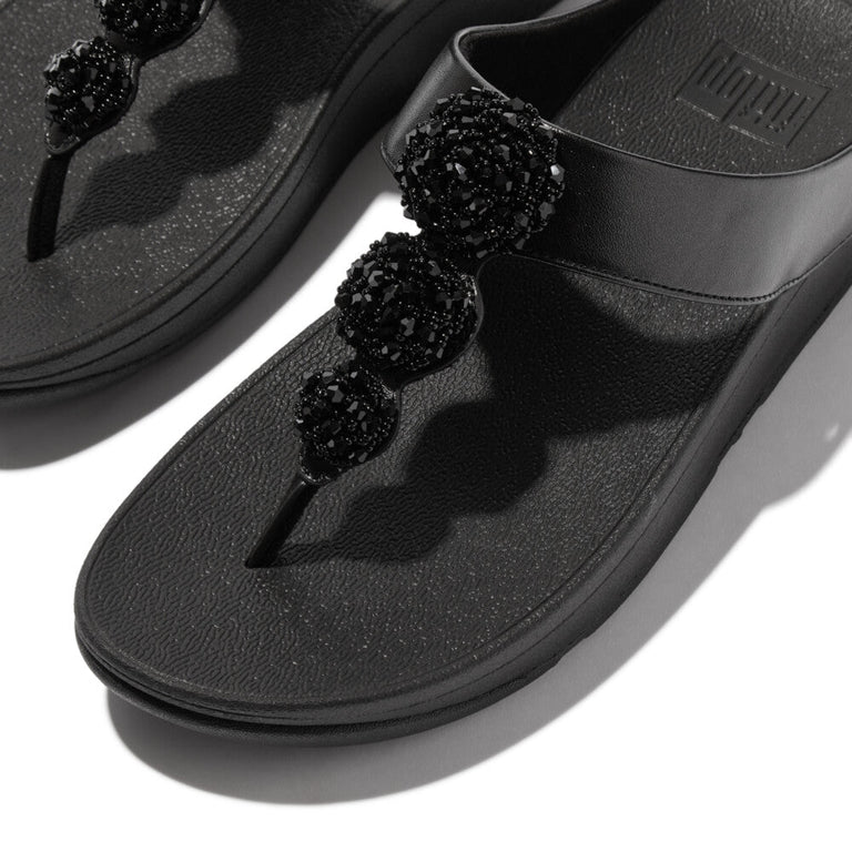 Discover the FitFlop Fino Beadie Button Metallic Toe-Post Sandals IU1 in Metallic Black – elegant, beaded, and designed for all-day comfort with signature Microwobbleboard™ technology.