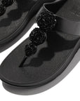 Discover the FitFlop Fino Beadie Button Metallic Toe-Post Sandals IU1 in Metallic Black – elegant, beaded, and designed for all-day comfort with signature Microwobbleboard™ technology.