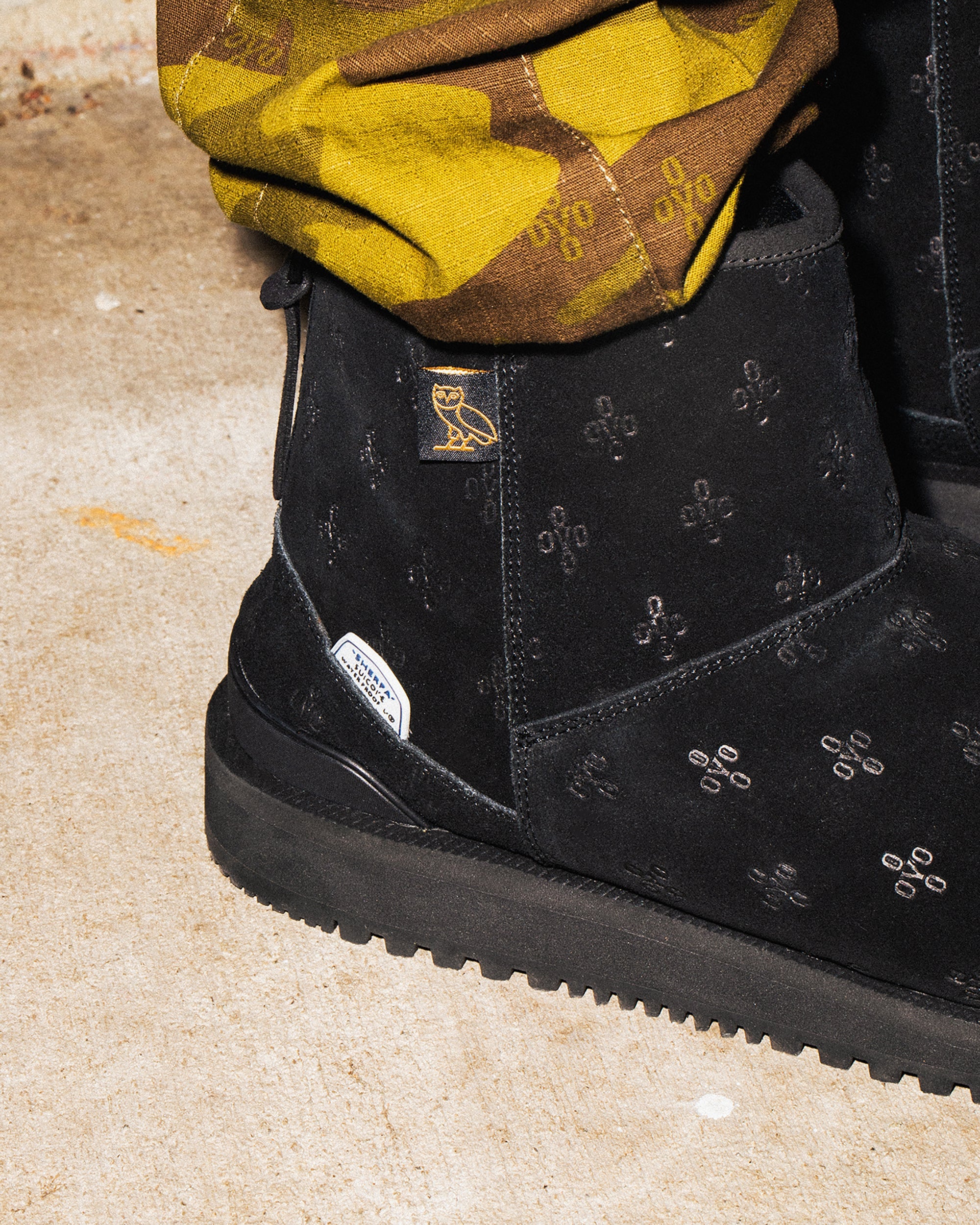 SUICOKE ELS-Mwpab-MID boots with shearling lining, black upper, black midsole and sole, zip closure at heel, OVO monogram debossed pattern, rubberized logo applied in white, tonal rubber trim with embossed logo at heel, antibacterial EVA footbed, and VIBRAM¬¨¬®‚àö√ú arctic grip outsole. From Fall/Winter 2021 collection on SUICOKE Official US & Canada Webstore.