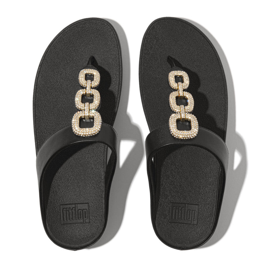 HX2 001 Black ergonomic sandals by FitFlop featuring a sleek leather T-bar, shimmering crystal-chain accents, and APMA-approved cushioning support.