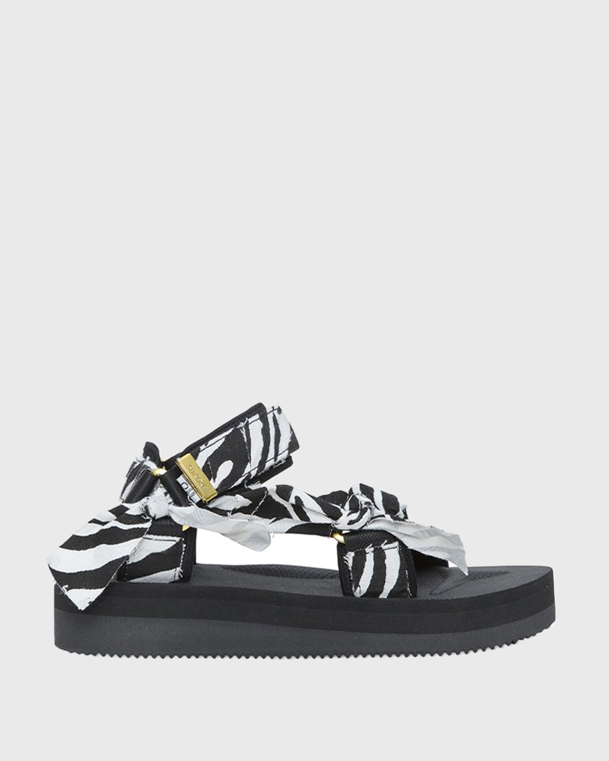 SUICOKE Depa-Fbcpocab-A black platform sandal with zebra printed straps + gold hardware logo tips. From SUICOKE SS21 collection.