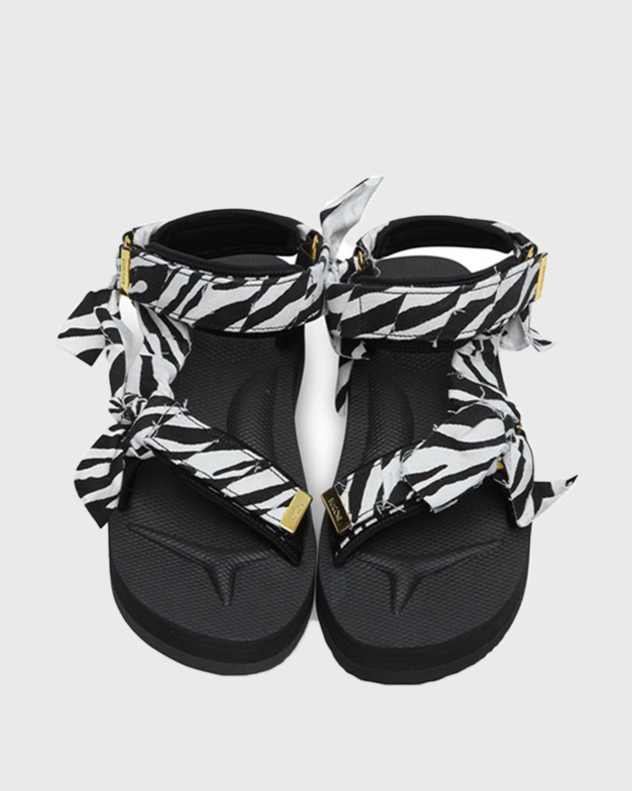 SUICOKE Depa-Fbcpocab-A black platform sandal with zebra printed straps + gold hardware logo tips. From SUICOKE SS21 collection.