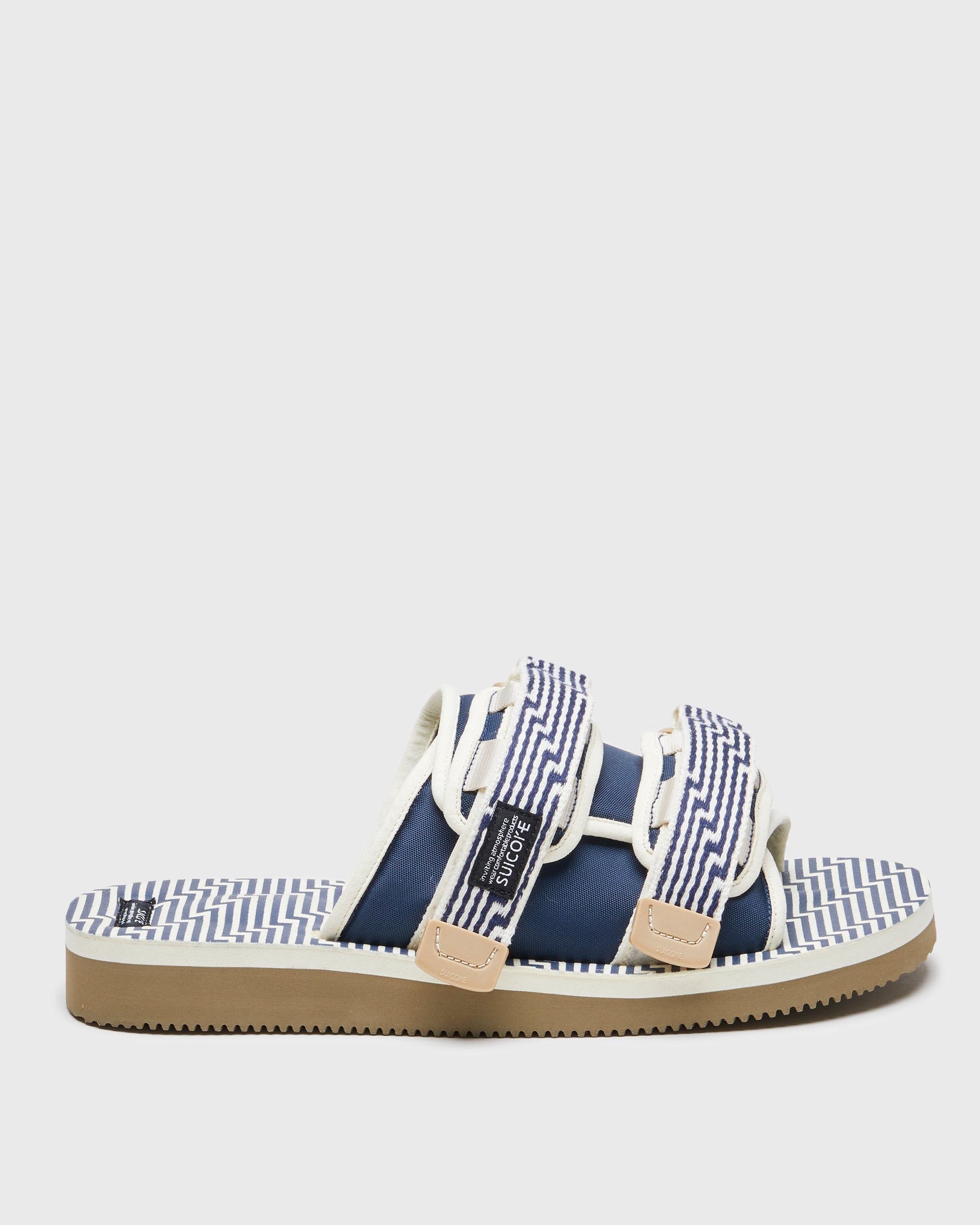 SUICOKE MOTO-JC01 slides with ivory & navy nylon upper, ivory & navy midsole and sole, strap and logo patch. From Spring/Summer 2023 collection on SUICOKE Official US & Canada Webstore. OG-056-JC01 IVORY X NAVY