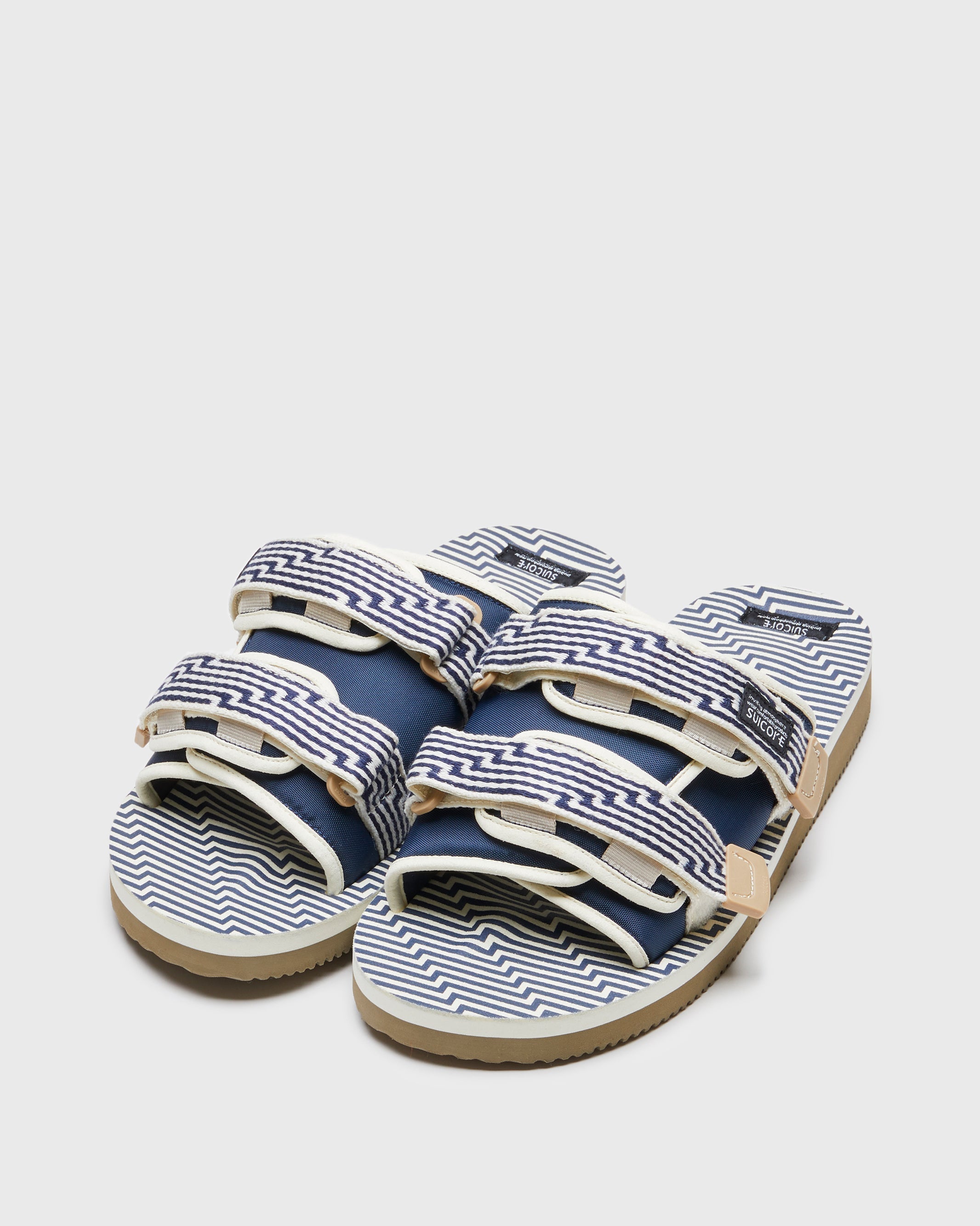 SUICOKE MOTO-JC01 slides with ivory & navy nylon upper, ivory & navy midsole and sole, strap and logo patch. From Spring/Summer 2023 collection on SUICOKE Official US & Canada Webstore. OG-056-JC01 IVORY X NAVY