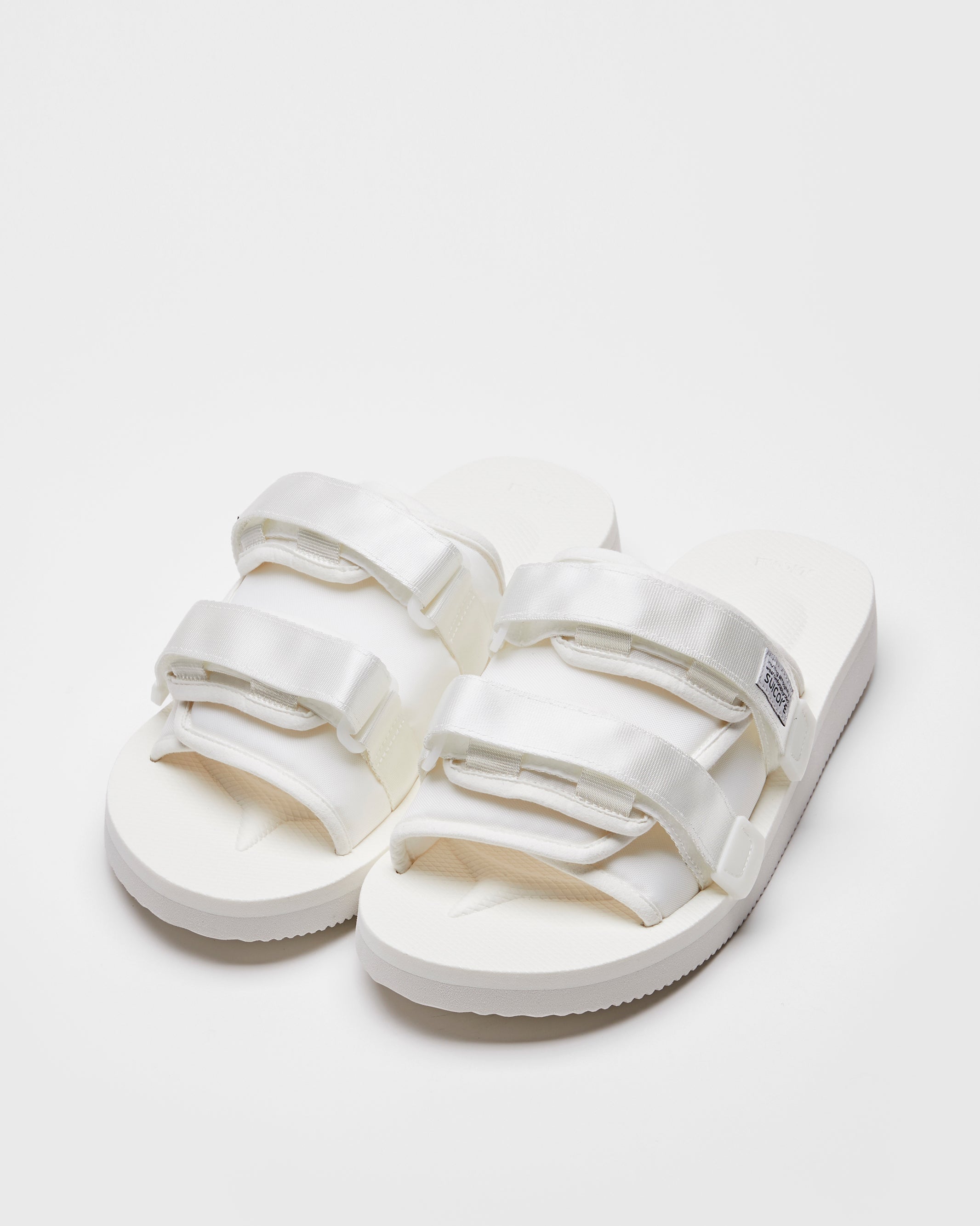 SUICOKE MOTO-Cab slides with white nylon upper, white midsole and sole, straps and logo patch. From Spring/Summer 2022 collection on SUICOKE Official US & Canada Webstore.