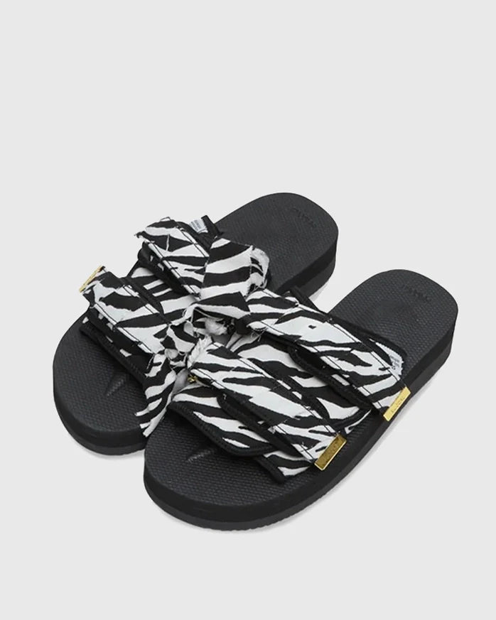 SUICOKE Moto-Fbcpocab black platform slide, with a zebra print upper and straps. Gold logo tip hardware on the end of double strap. From SUICOKE SS21 collection.