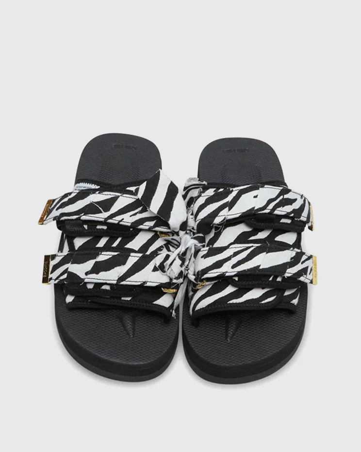 SUICOKE Moto-Fbcpocab black platform slide, with a zebra print upper and straps. Gold logo tip hardware on the end of double strap. From SUICOKE SS21 collection.