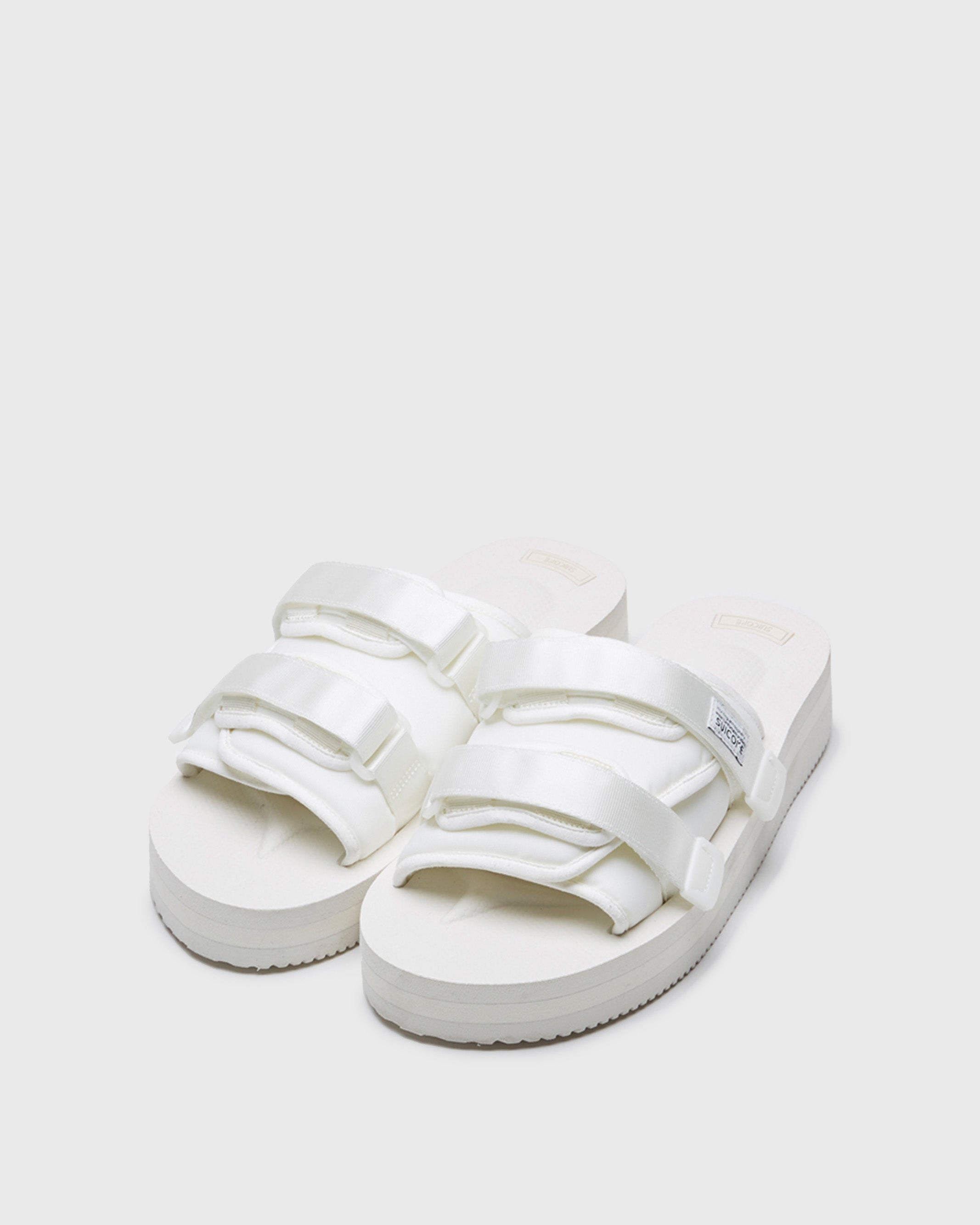 SUICOKE MOTO-VPO slides with white nylon upper, white midsole and sole, straps and logo patch. From Spring/Summer 2022 collection on SUICOKE Official US & Canada Webstore.