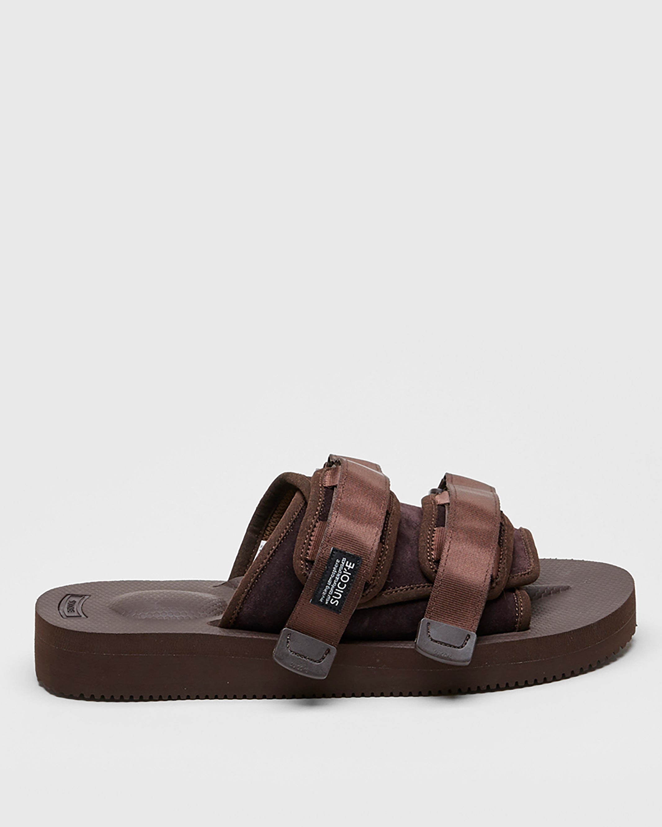 SUICOKE MOTO-VS slides with brown cow suede upper, brown midsole and sole, straps and logo patch. From Spring/Summer 2022 collection on SUICOKE Official US & Canada Webstore.