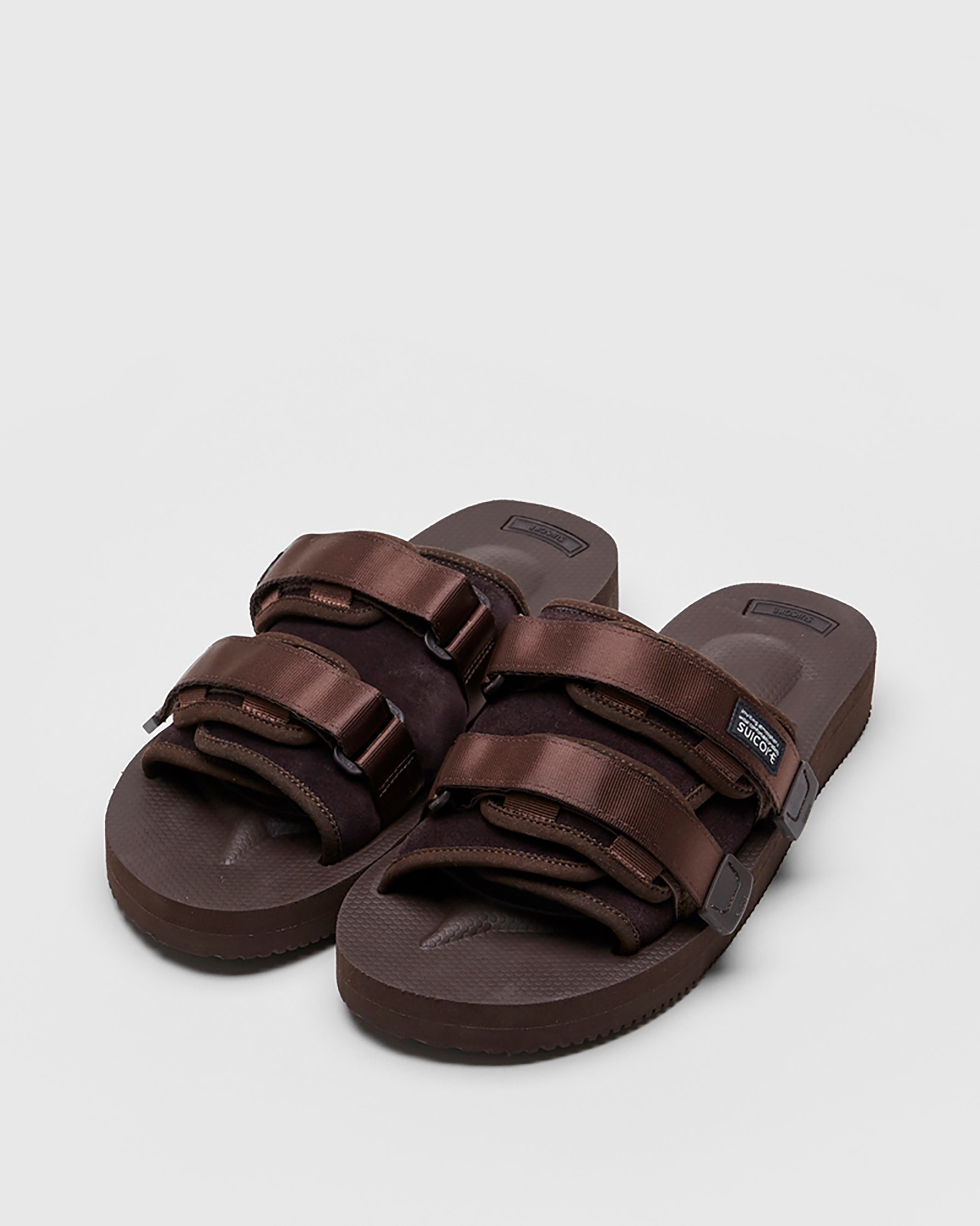 SUICOKE MOTO-VS slides with brown cow suede upper, brown midsole and sole, straps and logo patch. From Spring/Summer 2022 collection on SUICOKE Official US & Canada Webstore.