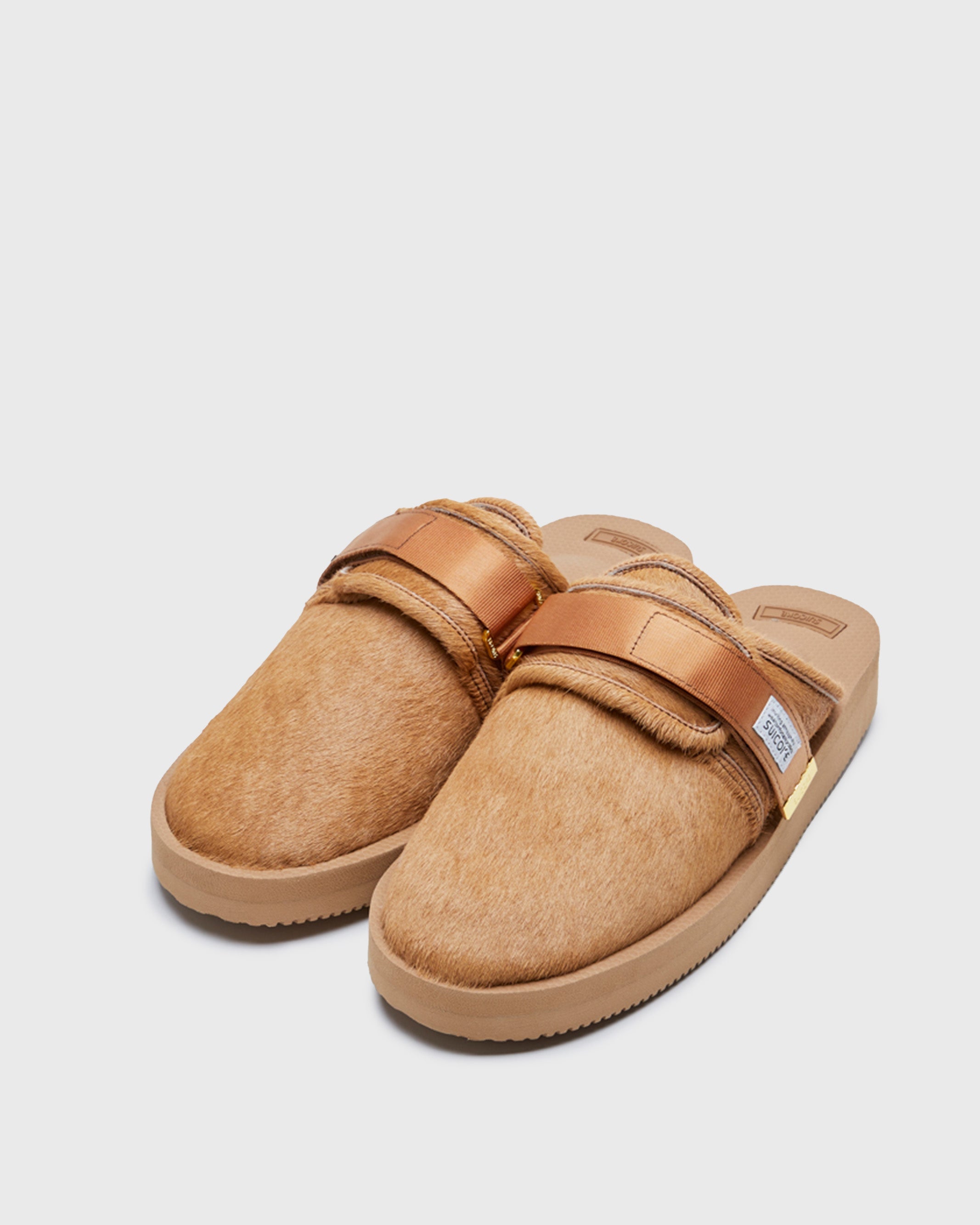 SUICOKE ZAVO-Vhl closed toe slides with camel colored calf hair upper, midsole and sole, straps and gold tabs with logo patch and piping on SUICOKE Official US & Canada Webstore.