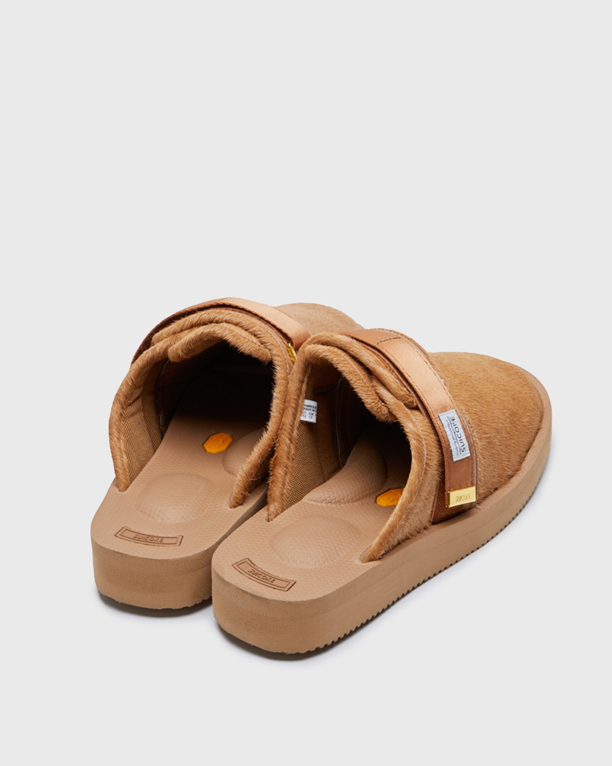 SUICOKE ZAVO-Vhl closed toe slides with camel colored calf hair upper, midsole and sole, straps and gold tabs with logo patch and piping on SUICOKE Official US & Canada Webstore.