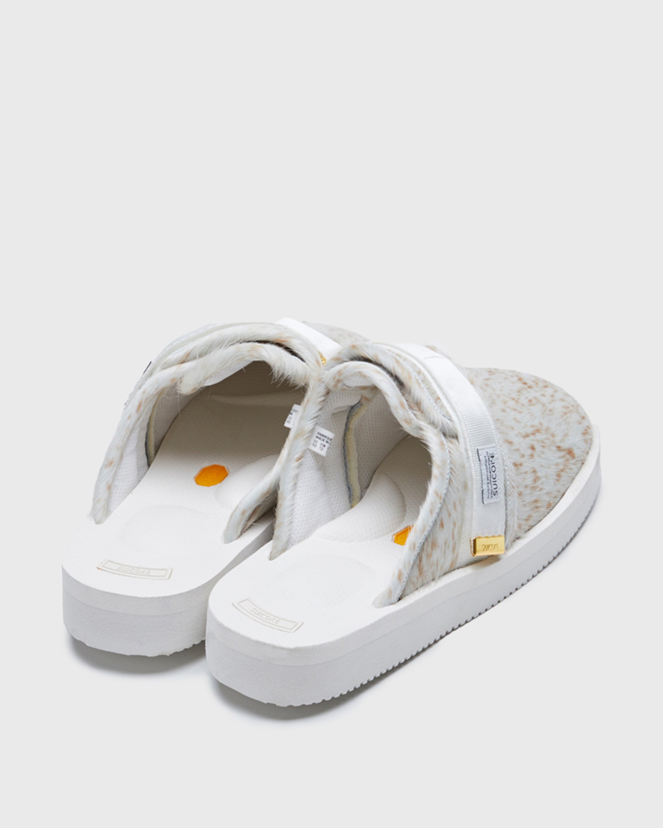 SUICOKE ZAVO-Vhl closed toe slides with white-brown speckled colored calf hair upper, white midsole and sole, nylon straps with logo patch and gold logoed tabs on SUICOKE Official US & Canada Webstore.