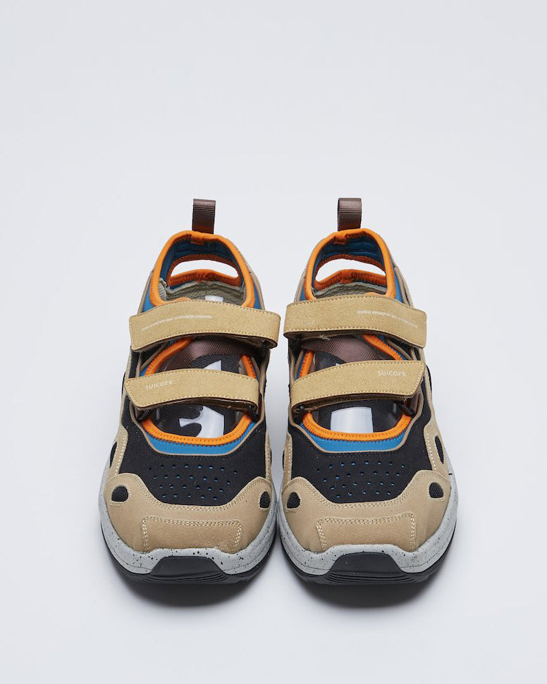 SUICOKE AKK-ab shoe with blue polyester, brown nylon and black and beige suede, gray rubber running midsole and black sole. Upper finished with orange piping, beige velcro straps with heel loop. Small openings at heel and top where straps are placed. From Fall/Winter 2021 collection on SUICOKE Official US & Canada Webstore.