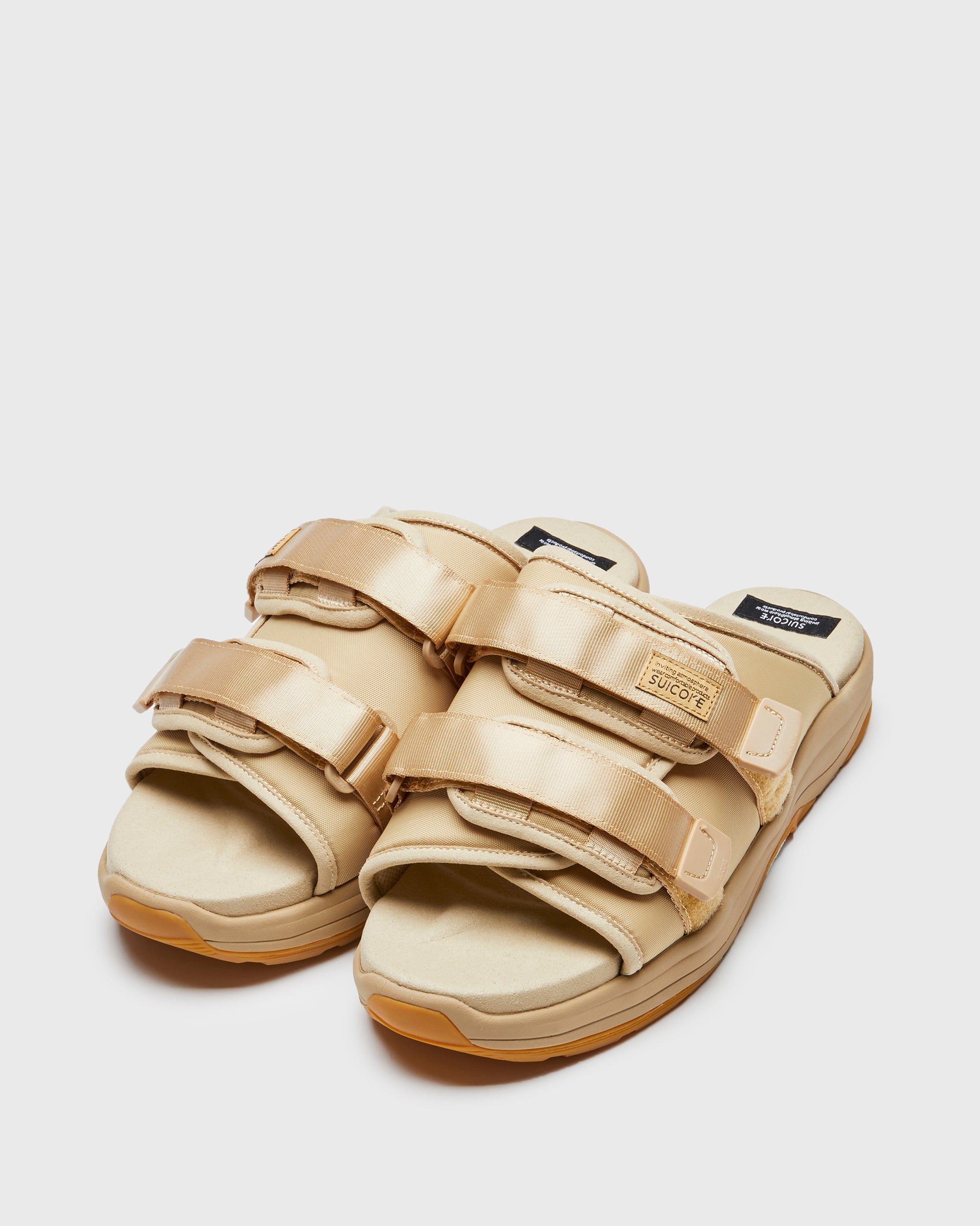 SUICOKE MOTO-Run slides with beige nylon upper, beige midsole and sole, strap and logo patch. From Spring/Summer 2023 collection on SUICOKE Official US & Canada Webstore. OG-332 BEIGE