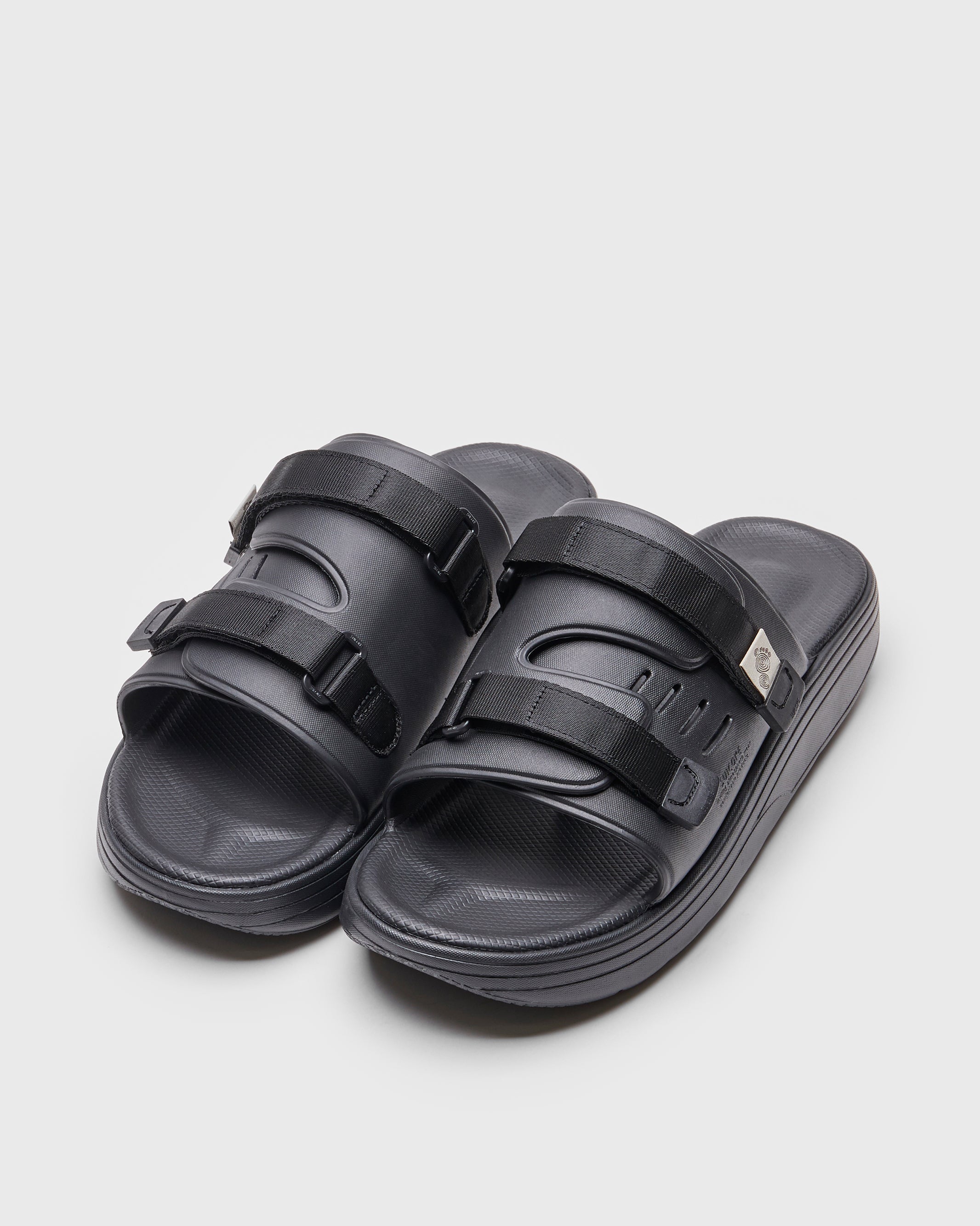 SUICOKE URICH slides with black rubber upper, black midsole and sole, straps and logo patch. From Spring/Summer 2022 collection on SUICOKE Official US & Canada Webstore. OG-INJ-01 BLACK