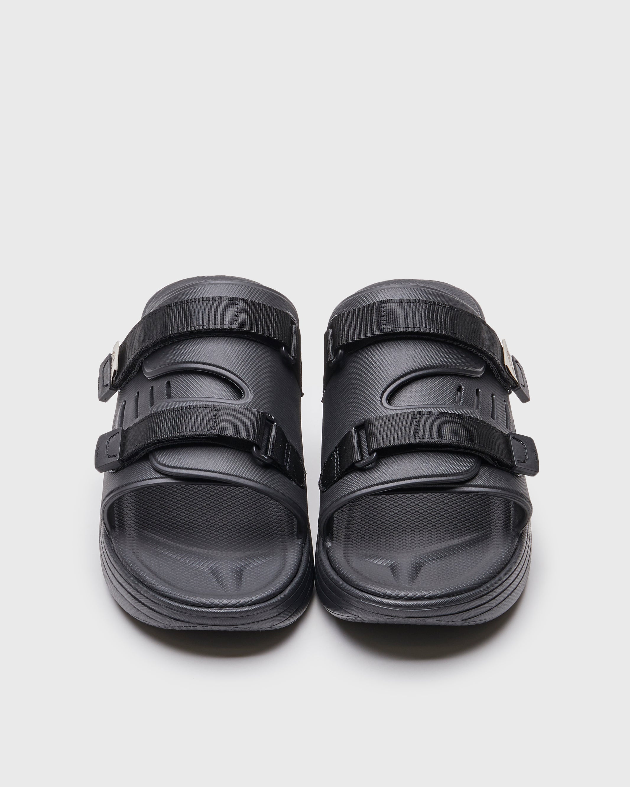 SUICOKE URICH slides with black rubber upper, black midsole and sole, straps and logo patch. From Spring/Summer 2022 collection on SUICOKE Official US & Canada Webstore. OG-INJ-01 BLACK