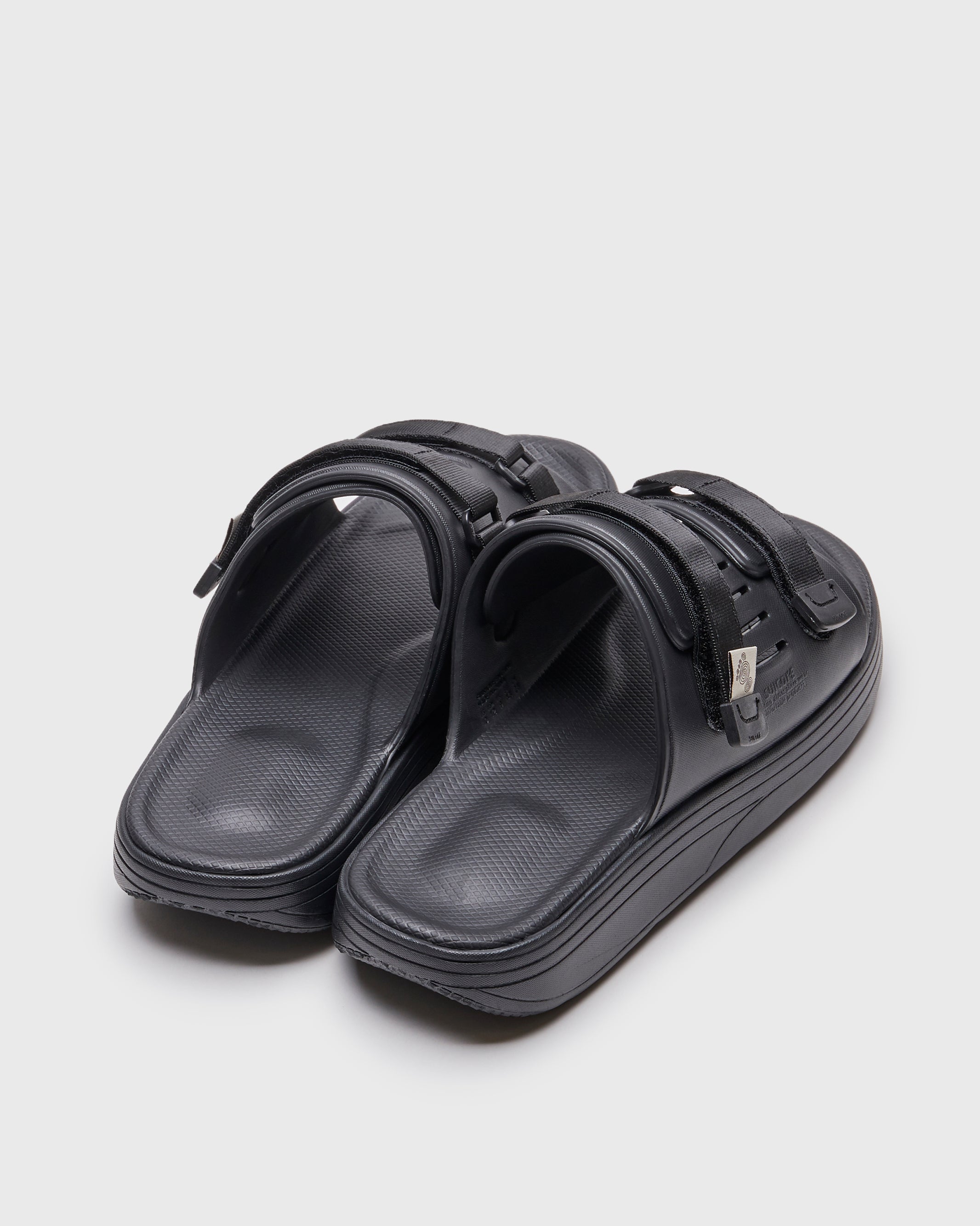 SUICOKE URICH slides with black rubber upper, black midsole and sole, straps and logo patch. From Spring/Summer 2022 collection on SUICOKE Official US & Canada Webstore. OG-INJ-01 BLACK