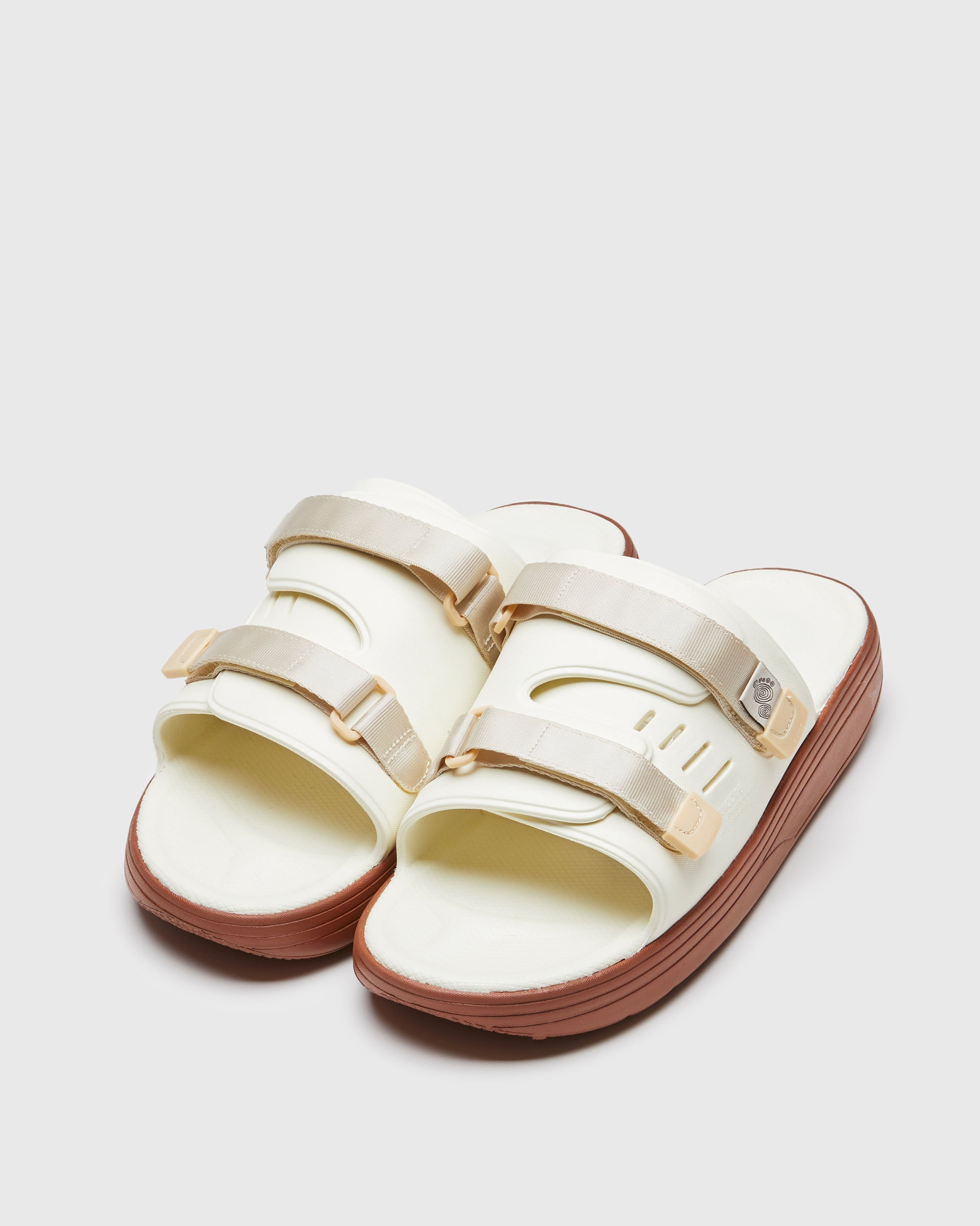 SUICOKE URICH slides with off-white rubber upper, off-white rubber midsole and sole, off white nylon strap and logo patch. From Spring/Summer 2023 collection on SUICOKE Official US & Canada Webstore. OG-INJ-01 OFF WHITE