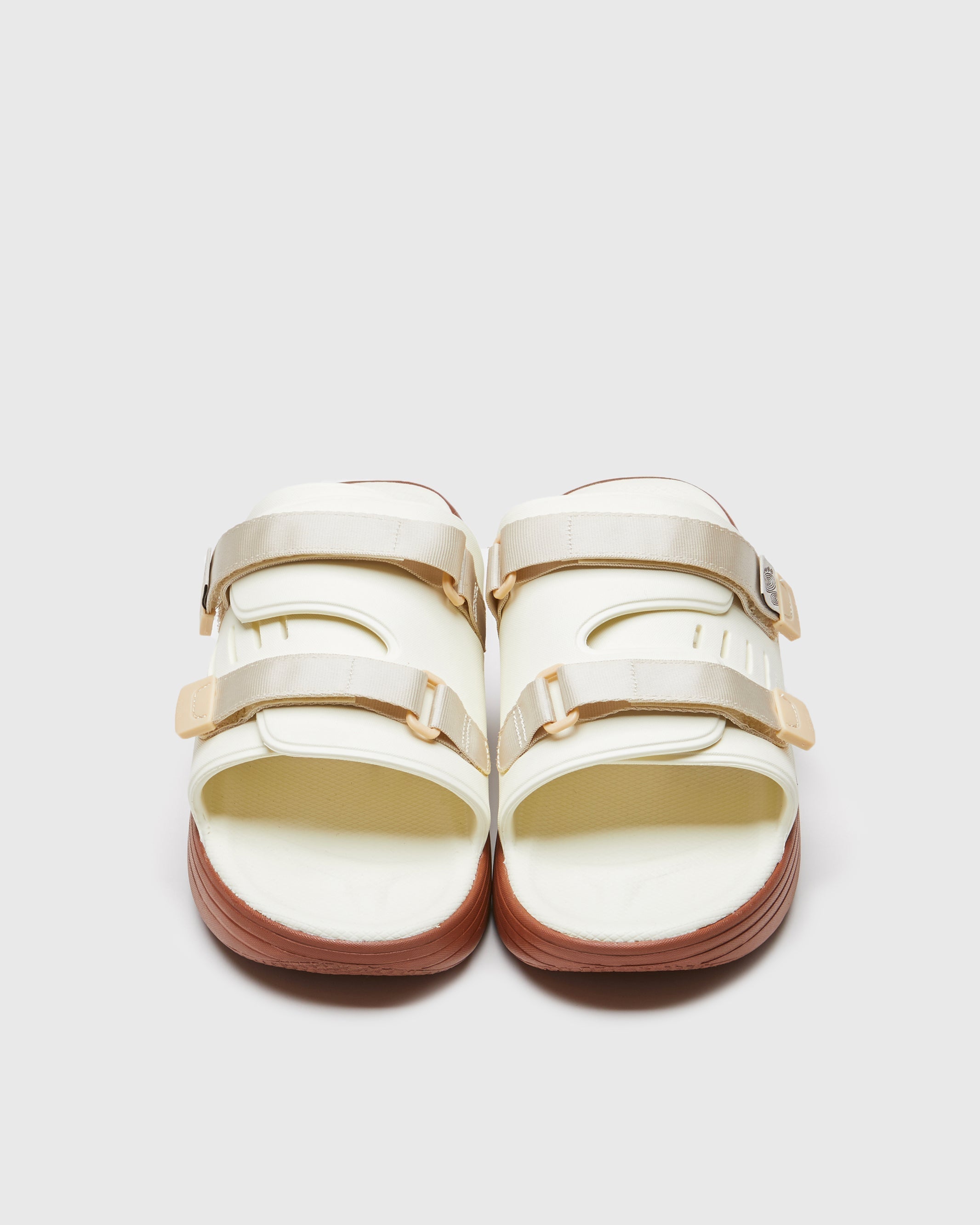 SUICOKE URICH slides with off-white rubber upper, off-white rubber midsole and sole, off white nylon strap and logo patch. From Spring/Summer 2023 collection on SUICOKE Official US & Canada Webstore. OG-INJ-01 OFF WHITE