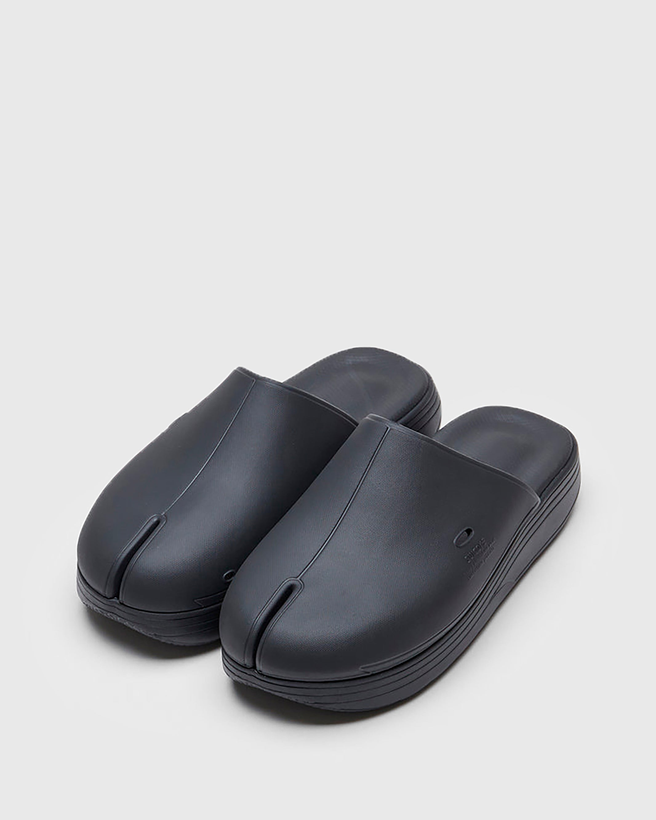 SUICOKE POLK slides with black rubber upper, black midsole and sole, straps and logo patch. From Spring/Summer 2022 collection on SUICOKE Official US & Canada Webstore. OG-INJ-04 BLACK