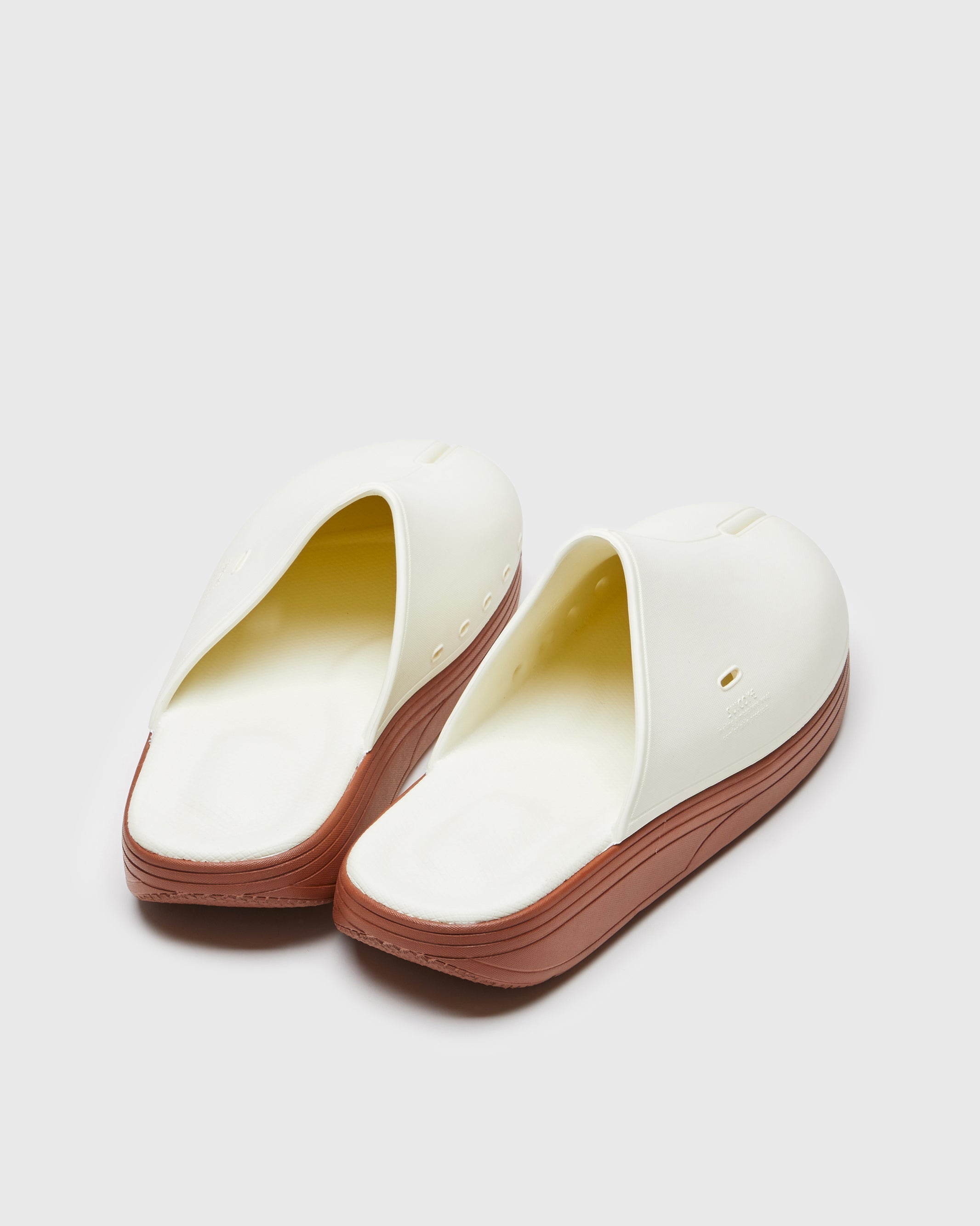 SUICOKE POLK slides with off-white rubber upper, off-white rubber midsole and sole, and logo patch. From Spring/Summer 2023 collection on SUICOKE Official US & Canada Webstore. OG-INJ-04 OFF WHITE.