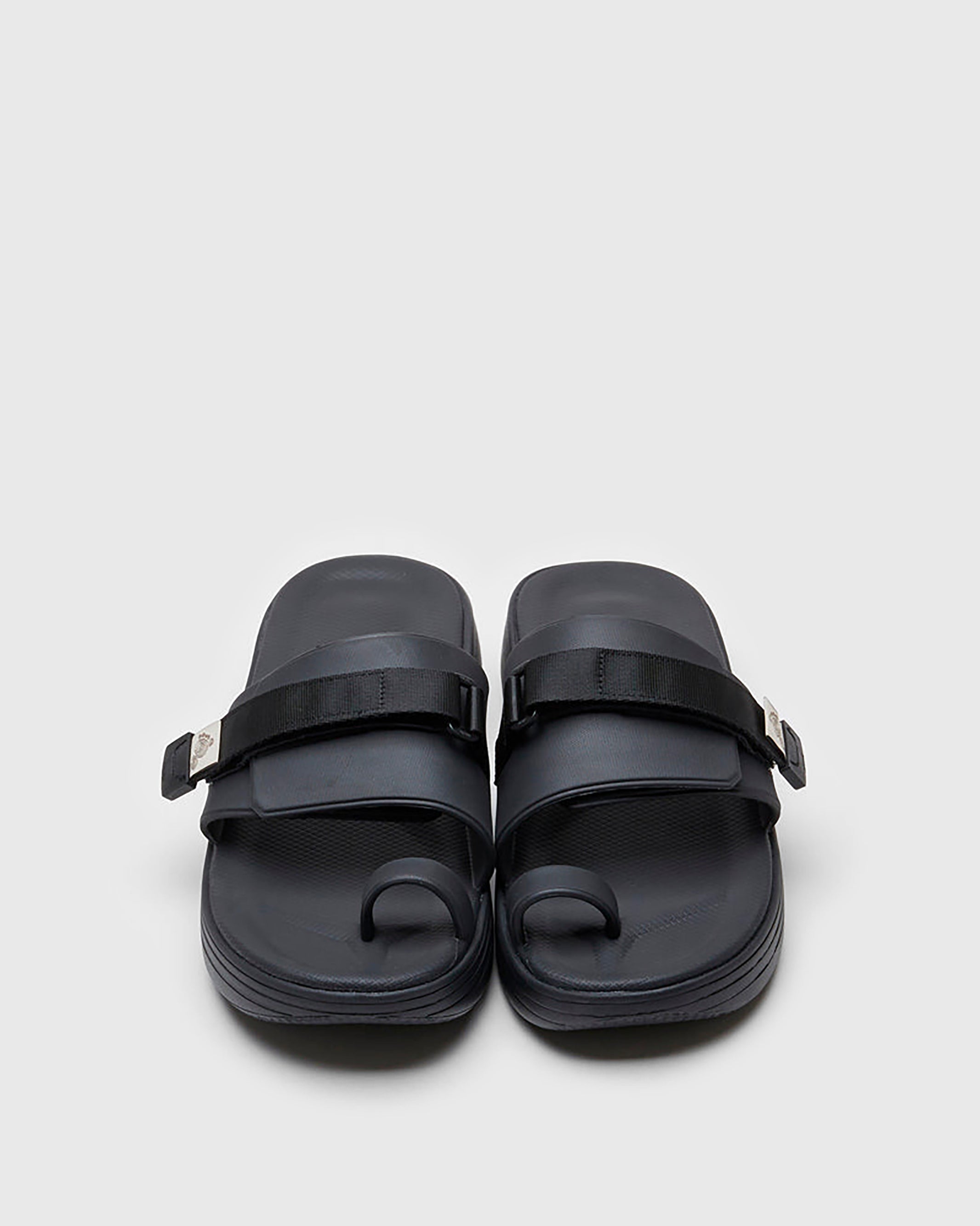 SUICOKE UTA slides with black rubber upper, black midsole and sole, straps and logo patch. From Spring/Summer 2022 collection on SUICOKE Official US & Canada Webstore.