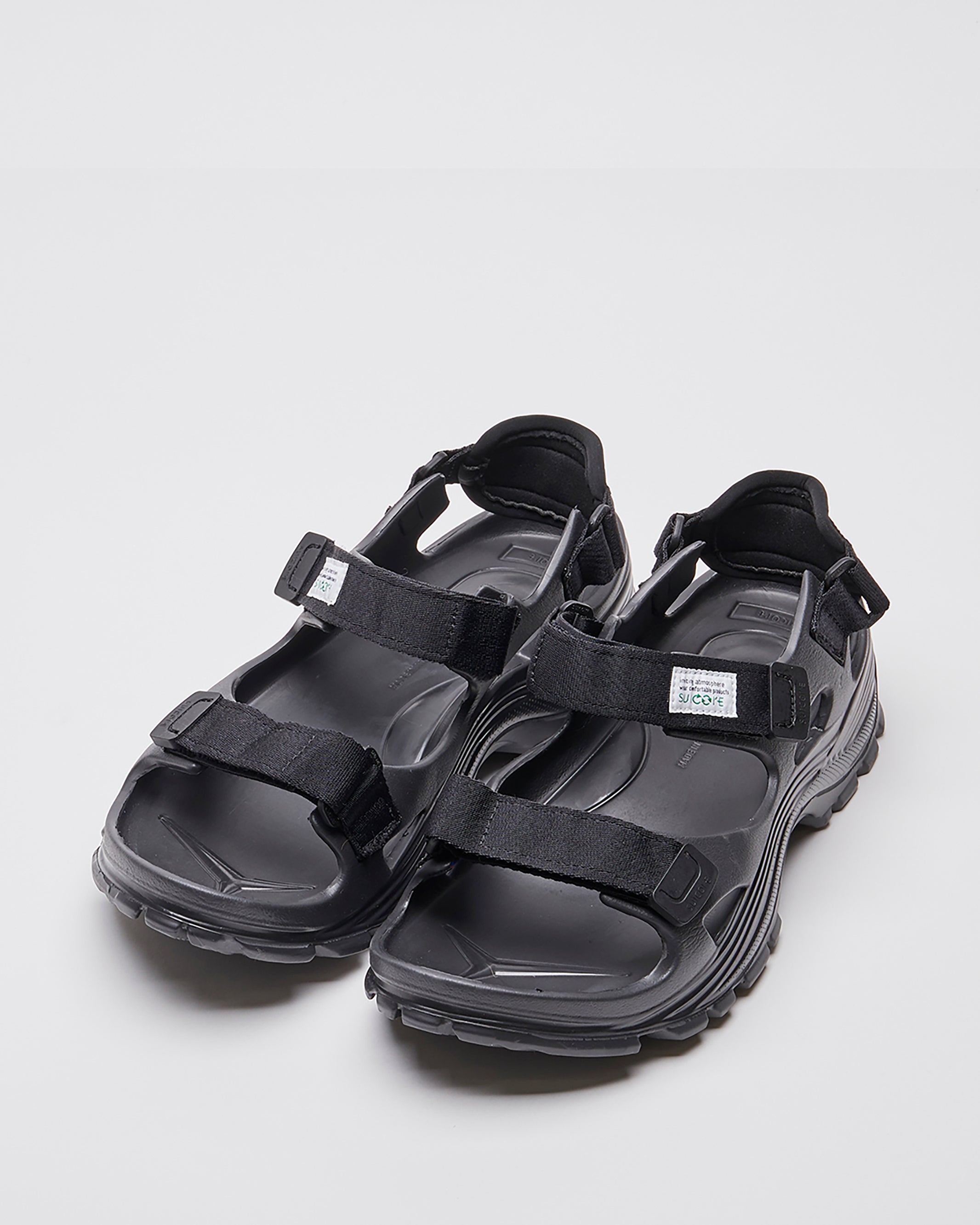 SUICOKE WAKE sandals with black rubber upper, black midsole and sole, straps and logo patch. From Spring/Summer 2023 collection on SUICOKE Official US & Canada Webstore. OG-INJ-100 BLACK