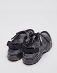 SUICOKE WAKE sandals with black rubber upper, black midsole and sole, straps and logo patch. From Spring/Summer 2023 collection on SUICOKE Official US & Canada Webstore. OG-INJ-100 BLACK