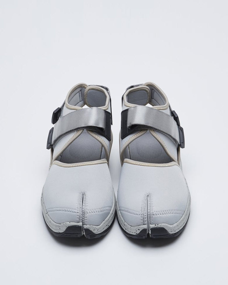 SUICOKE UNBITA-ab split toe shoe with gray nylon closed toe upper and ankle covering with gray straps and logo tag and gray running sole with black speckles. From Fall/Winter 2021 collection on SUICOKE Official US & Canada Webstore.