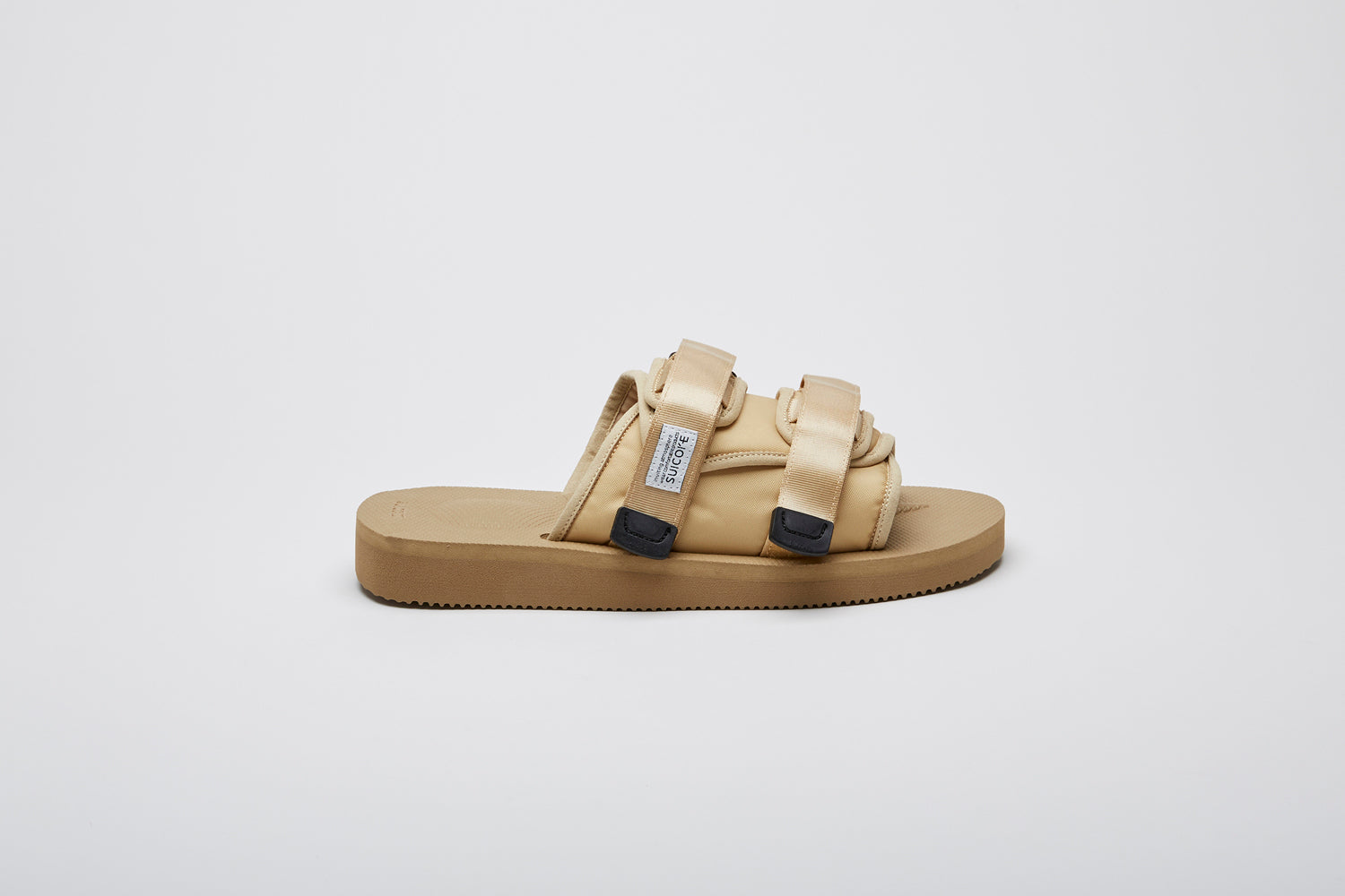 SUICOKE MOTO-Cab slides with beige nylon upper, beige midsole and sole, straps and logo patch. From Spring/Summer 2023 collection on eightywingold Web Store, an official partner of SUICOKE. OG-056CAB BEIGE