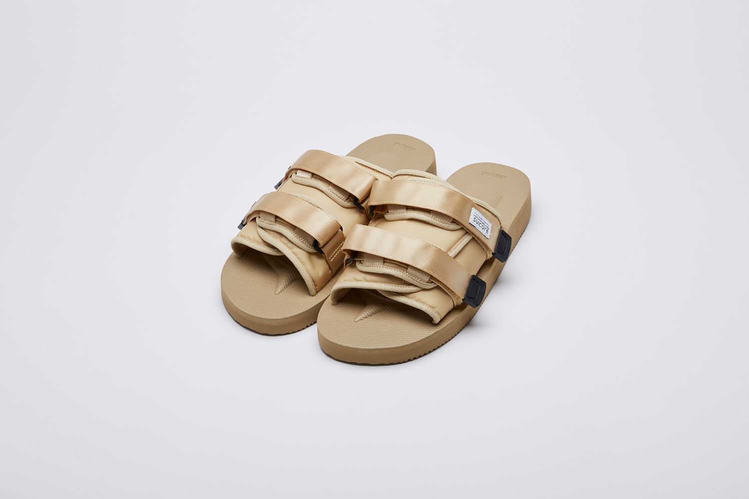 SUICOKE MOTO-Cab slides with beige nylon upper, beige midsole and sole, straps and logo patch. From Spring/Summer 2023 collection on eightywingold Web Store, an official partner of SUICOKE. OG-056CAB BEIGE