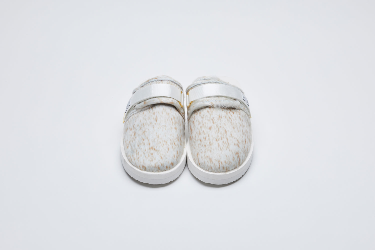 SUICOKE ZAVO-Vhl closed toe slides with white-brown speckled colored calf hair upper, white midsole and sole, nylon straps with logo patch and gold logoed tabs.  From Fall/Winter 2021 collection on SUICOKE Official US &amp; Canada Webstore.