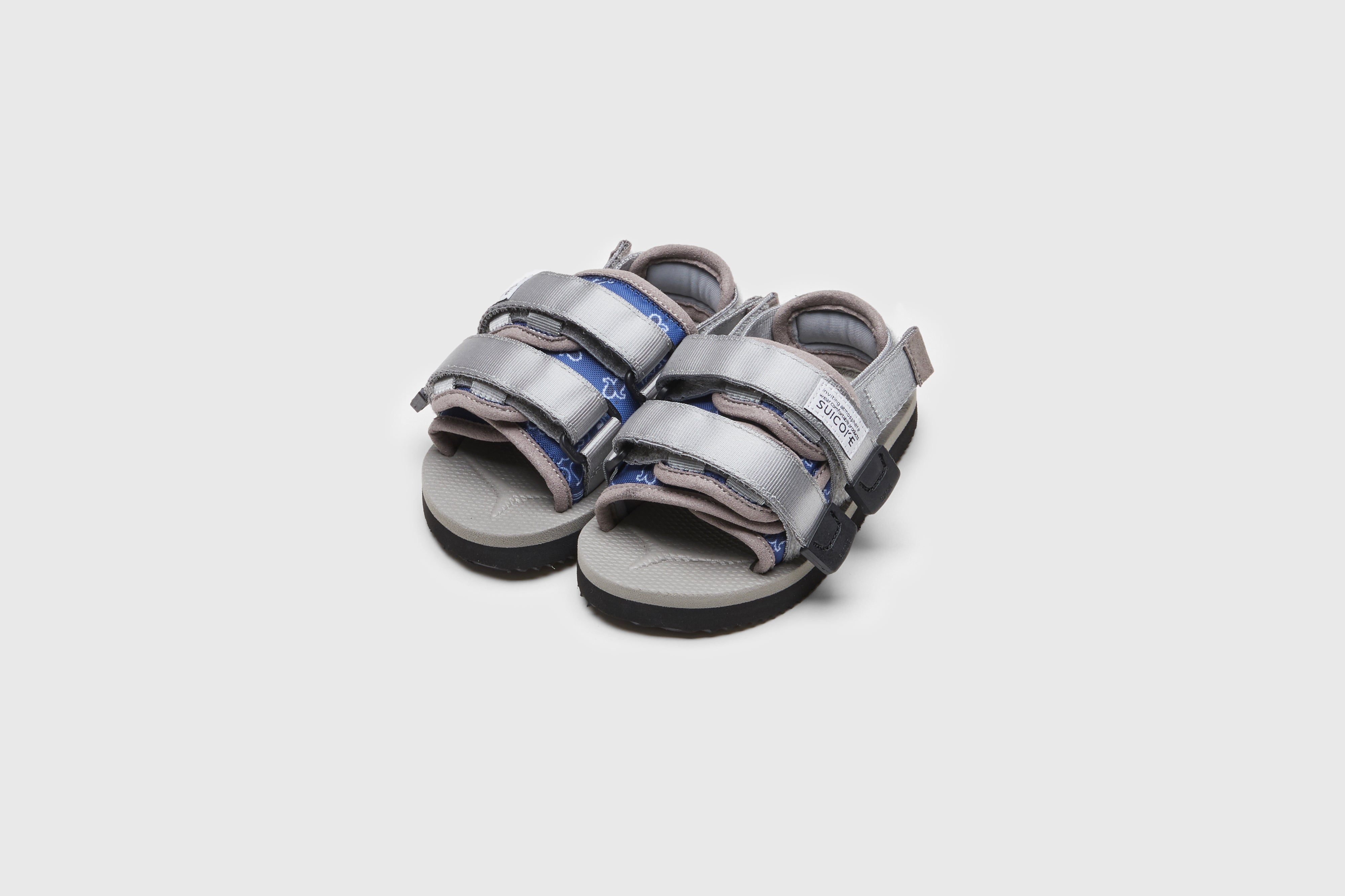 SUICOKE MOTO-2kids-PT05 slides with navy &amp; gray nylon upper, navy &amp; gray midsole and sole, strap and logo patch. From Spring/Summer 2023 collection on eightywingold Web Store, an official partner of SUICOKE. OG-056-2KIDS-PT05 NAVY X GRAY