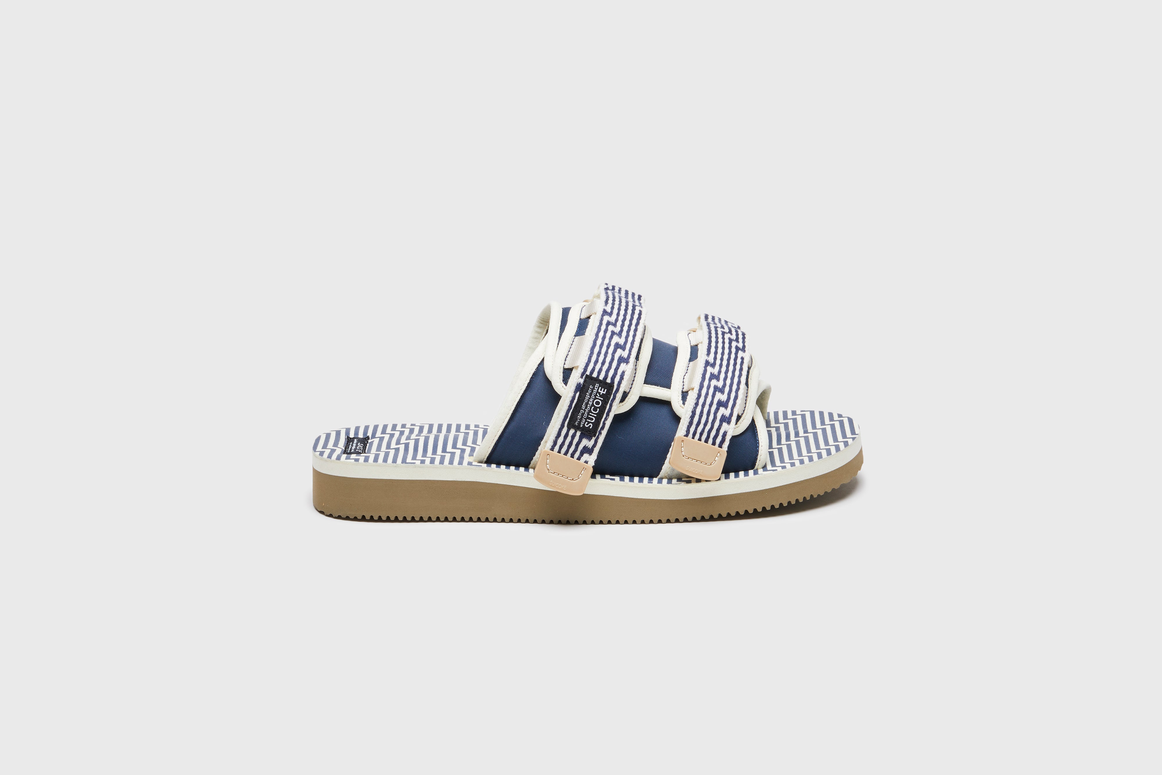 SUICOKE MOTO-JC01 slides with ivory & navy nylon upper, ivory & navy midsole and sole, strap and logo patch. From Spring/Summer 2023 collection on eightywingold Web Store, an official partner of SUICOKE. OG-056-JC01 IVORY X NAVY