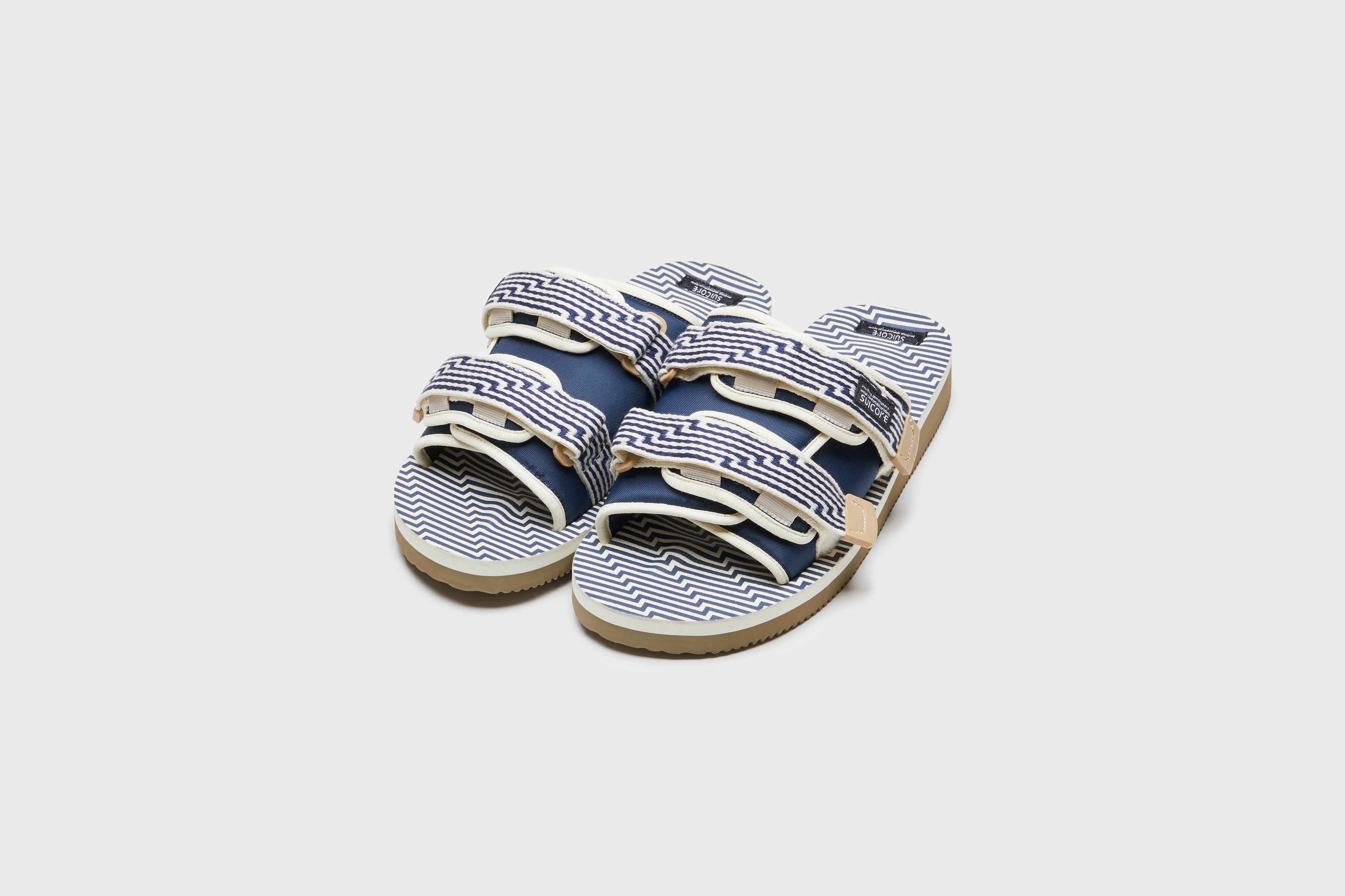 SUICOKE MOTO-JC01 slides with ivory & navy nylon upper, ivory & navy midsole and sole, strap and logo patch. From Spring/Summer 2023 collection on eightywingold Web Store, an official partner of SUICOKE. OG-056-JC01 IVORY X NAVY