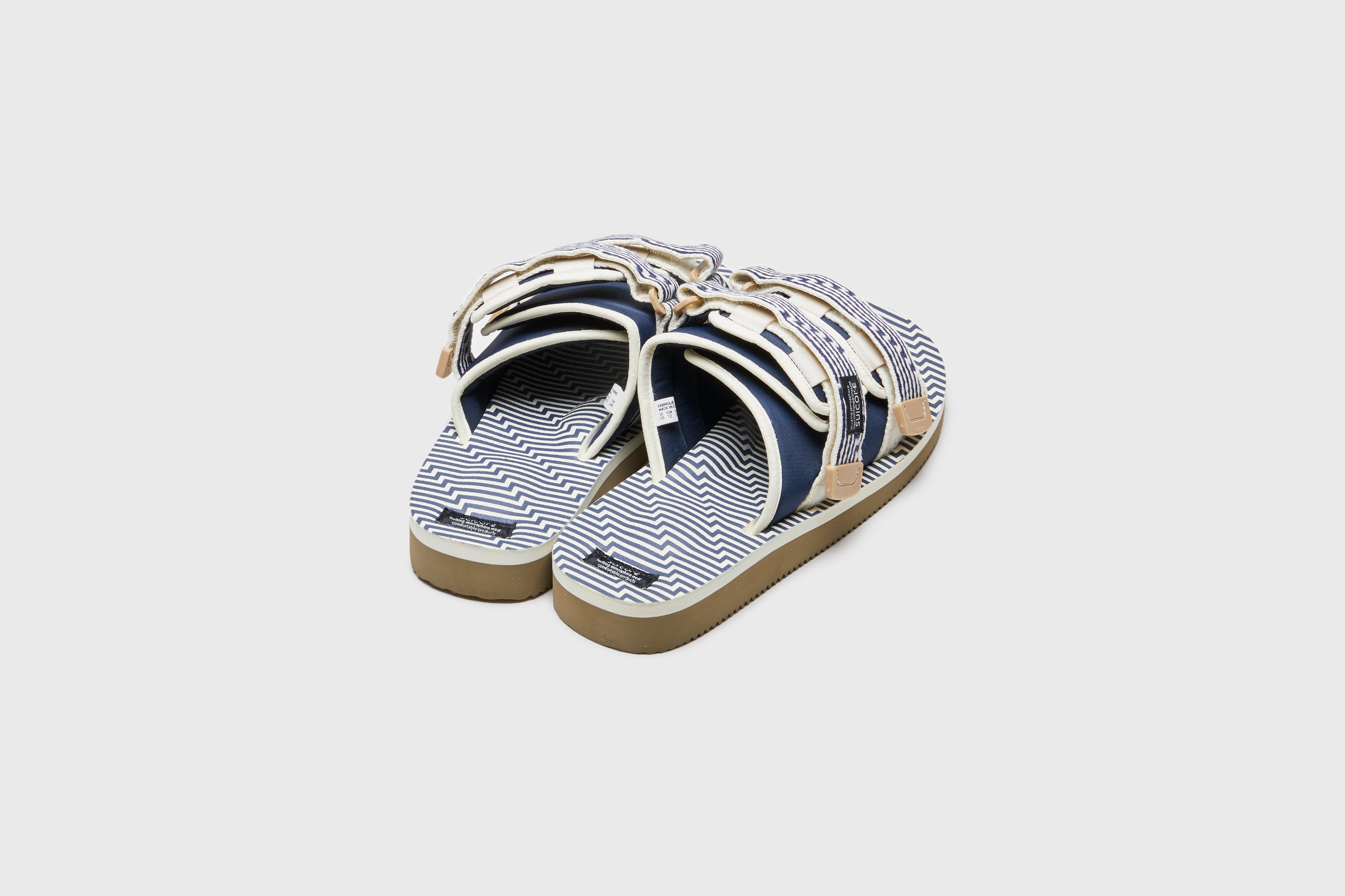 SUICOKE MOTO-JC01 slides with ivory &amp; navy nylon upper, ivory &amp; navy midsole and sole, strap and logo patch. From Spring/Summer 2023 collection on eightywingold Web Store, an official partner of SUICOKE. OG-056-JC01 IVORY X NAVY