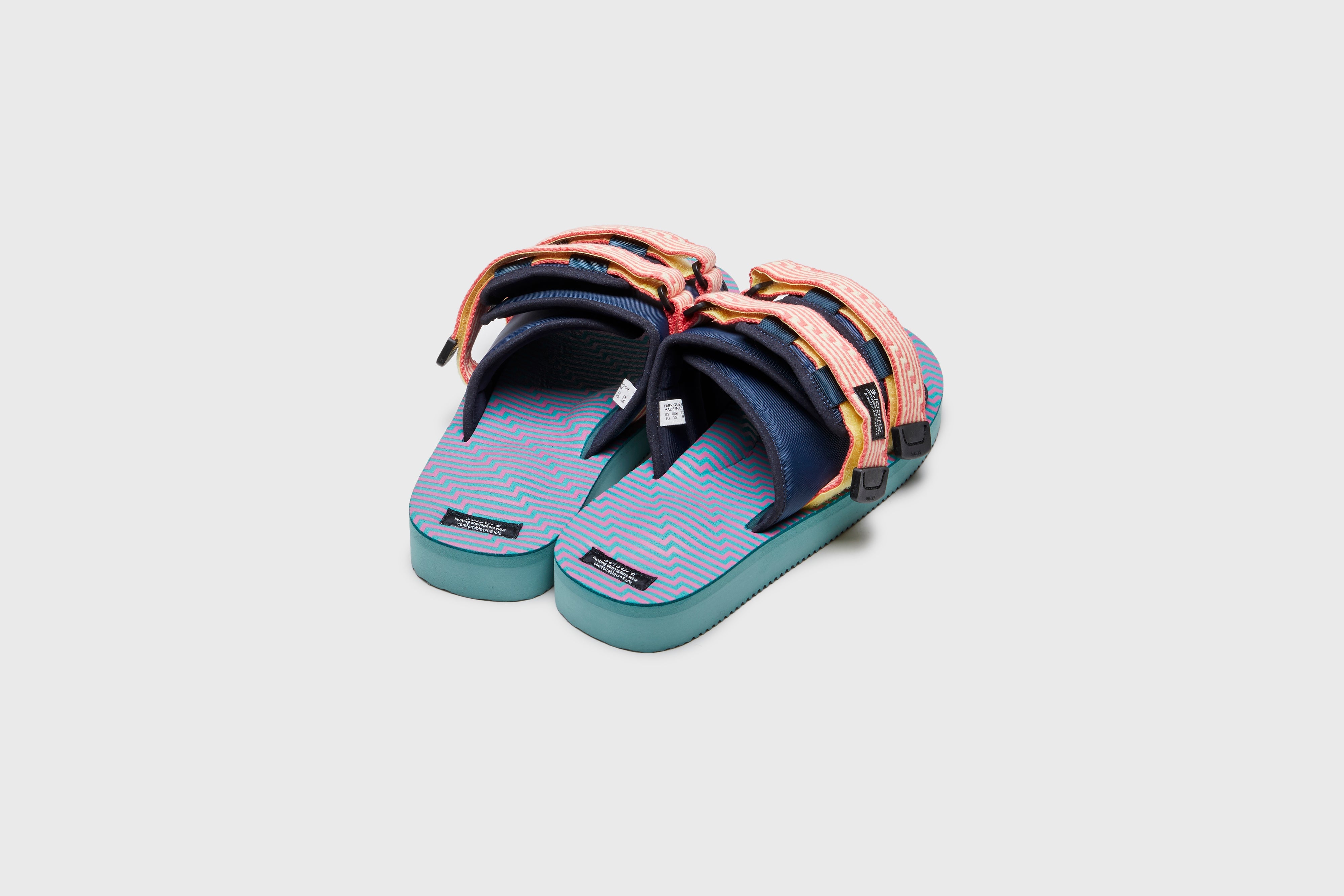 SUICOKE MOTO-JC01 slides with yellow & pink nylon upper, yellow & pink midsole and sole, strap and logo patch. From Spring/Summer 2023 collection on eightywingold Web Store, an official partner of SUICOKE. OG-056-JC01 YELLOW X PINK