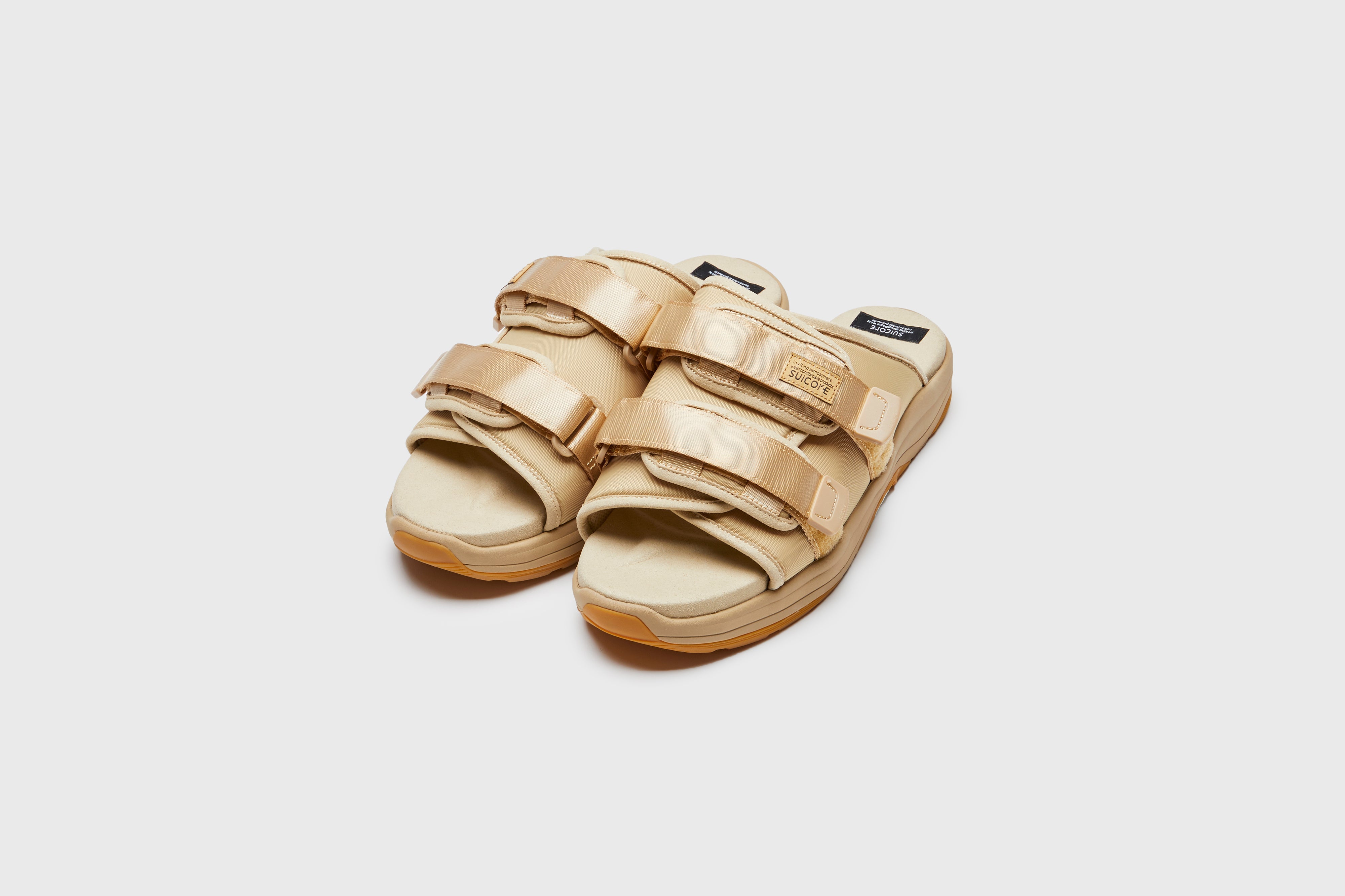 SUICOKE MOTO-Run slides with beige nylon upper, beige midsole and sole, strap and logo patch. From Spring/Summer 2023 collection on eightywingold Web Store, an official partner of SUICOKE. OG-332 BEIGE